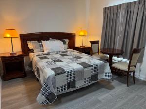 a bedroom with a bed and a table and chairs at Knights Inn London Ontario in London