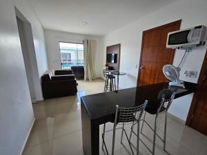 a kitchen and living room with a table and chairs at Apto Garden Taperapuan 2 quartos com suíte in Porto Seguro