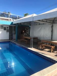 a swimming pool with a picnic table and a tent at Apto Garden Taperapuan 2 quartos com suíte in Porto Seguro