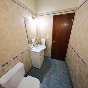 a small bathroom with a toilet and a sink at Pinar del Arroyito in Villa General Belgrano