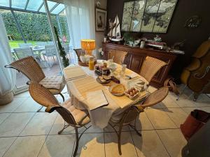 a dining room with a table and chairs with food on it at Au Bois Dormant in Monterblanc