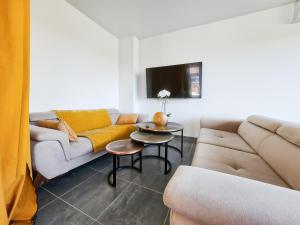 a living room with a couch and a table at Maison Familiale, Jardin Privé, Proche Disneyland in Coutevroult