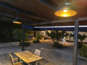 a patio with a wooden table and two lights at El Rincón del Olivo in Cartagena