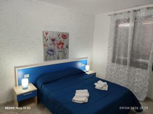 a bedroom with a blue bed with towels on it at Casa vacanza da Samuele in San Vito lo Capo