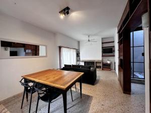 a living room with a wooden table and a couch at Casa amplia, céntrica y con garage en Junin, BA in Junín