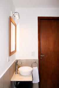 a bathroom with a white sink and a wooden door at Casa amplia, céntrica y con garage en Junin, BA in Junín +14 photos