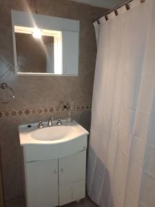 a bathroom with a white sink and a mirror at Tu hogar en Concordia in Concordia