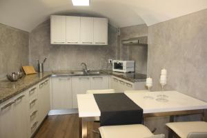 a kitchen with white cabinets and a table with chairs at Cal Arxè in Besalú
