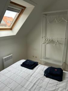 a bedroom with two beds in a room with a window at Residence Rodin in Nieuwpoort