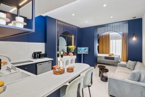 a kitchen and living room with blue walls at FatCow Suites City Centre in Larnaca