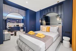 a bedroom with a large bed with blue walls at FatCow Suites City Centre in Larnaca