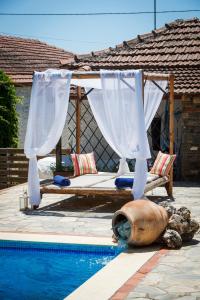 a bed with a canopy next to a swimming pool at Seranides Boutique Hotel in Kato Gatzea