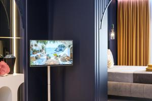 a tv hanging on a wall in a living room at FatCow Suites City Centre in Larnaca