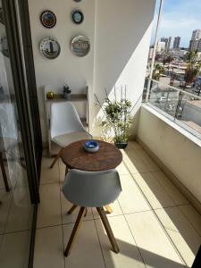 a small table and two chairs in a room with a window at A pasos de cavancha in Iquique +3 photos