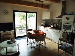 a kitchen with a table and some chairs and a table at "La Parenthèse balarucoise" in Balaruc-le-Vieux