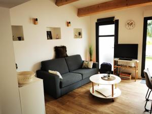 a living room with a couch and a table at "La Parenthèse balarucoise" in Balaruc-le-Vieux