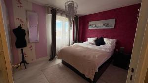 a bedroom with a bed with a red wall at Bellevue in Colmar