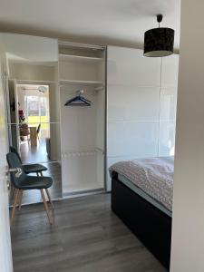 a bedroom with a bed and a chair in it at Maison de plain pied in Certines