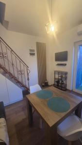a dining room with a wooden table and a staircase at Stella Sea House2 in Torvaianica