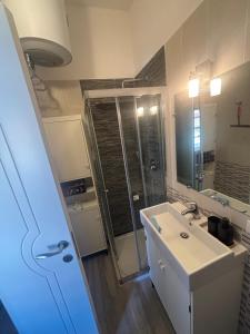 a bathroom with a shower and a white sink at Stella Sea House2 in Torvaianica +10 photos