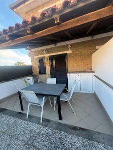 a patio with a table and chairs on a roof at Stella Sea House2 in Torvaianica
