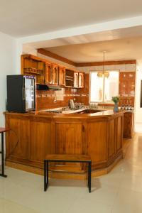 eine große Küche mit Holzschränken und einem Tisch in der Unterkunft Raizen Hostel in Dosquebradas