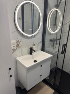 a bathroom with a sink and a shower with a mirror at Amazing Studio Close to Oldtown in Gdańsk +6 photos