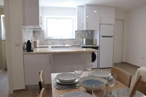 a kitchen with a table with plates and wine glasses at Lugar de São Braz in Alter do Chão