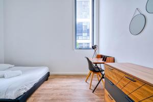 a bedroom with a bed and a desk with a chair at Gorgeous duplex near top attractions in Saint-Ouen
