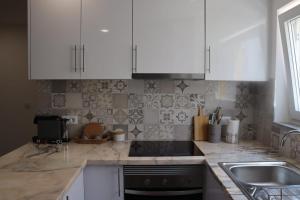 a kitchen with white cabinets and a sink at Lugar de São Braz in Alter do Chão