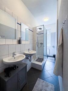 a bathroom with two sinks and a shower at City-Apartment Schöneweide in Berlin