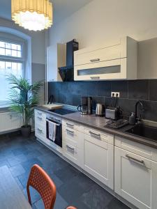 a kitchen with white cabinets and a stove top oven at City-Apartment Schöneweide in Berlin