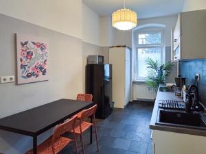 a kitchen with a black table and a refrigerator at City-Apartment Schöneweide in Berlin +12 photos