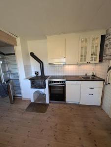 a kitchen with white cabinets and a stove top oven at Steneryd Salongen in Karlskrona