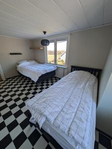 two beds in a room with a checkered floor at Steneryd Salongen in Karlskrona