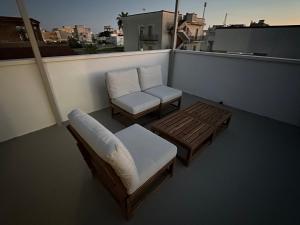a balcony with a couch and a chair and a table at Dune House in Ginosa Marina +50 photos