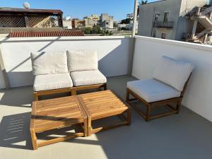 a balcony with two chairs and a table and a chair at Dune House in Ginosa Marina