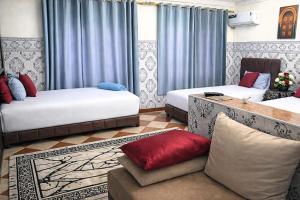 a living room with two beds and a couch at Riad Imperial Atlas in Meknès +29 photos