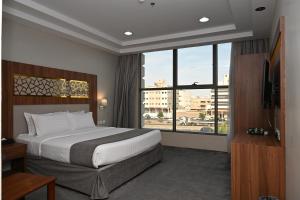 a hotel room with a bed and a large window at Salsbil Almasi Hotel in Medina +81 photos