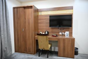 a desk with a television and a chair in a room at Salsbil Almasi Hotel in Medina