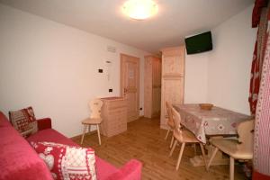 ein Wohnzimmer mit einem Tisch, Stühlen und einem Sofa in der Unterkunft Appartamenti Albert in Canazei