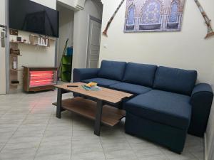 a living room with a blue couch and a table at Appartement familial شقة للعائلة in Meknès