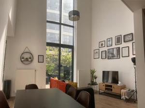 a living room with a table and a tv at Gorgeous duplex near top attractions in Saint-Ouen