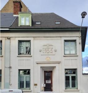 a white building with a clock on it at Duplex with Jacuzzi - Grand place Arras in Arras