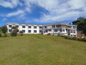 a large building on top of a grass field at Complejo Turistico Arena Gruesa in Ancud