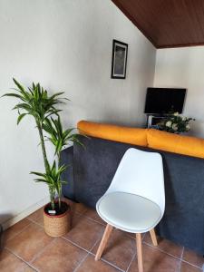 a white chair and a desk with a computer at A Casa dos Avós in Cativelos