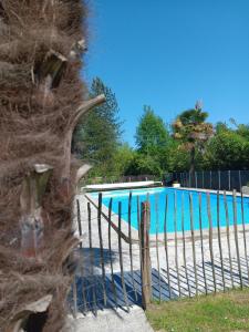 a fence next to a swimming pool at Le Moulin du Comte - chambres privées en gîte in Bourrouillan