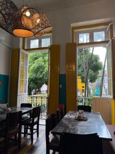a dining room with tables and chairs and windows at Sobrado Antonieta in Belém