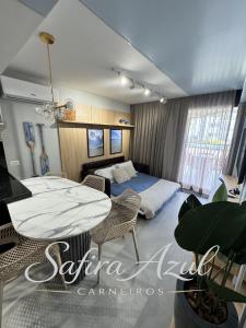 a bedroom with a bed and a table and chairs at Safira Azul Luxury Flat Carneiros in Tamandaré