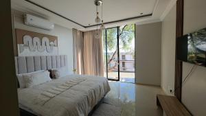 a bedroom with a bed and a large window at VnA Executive Suites in Pretoria
